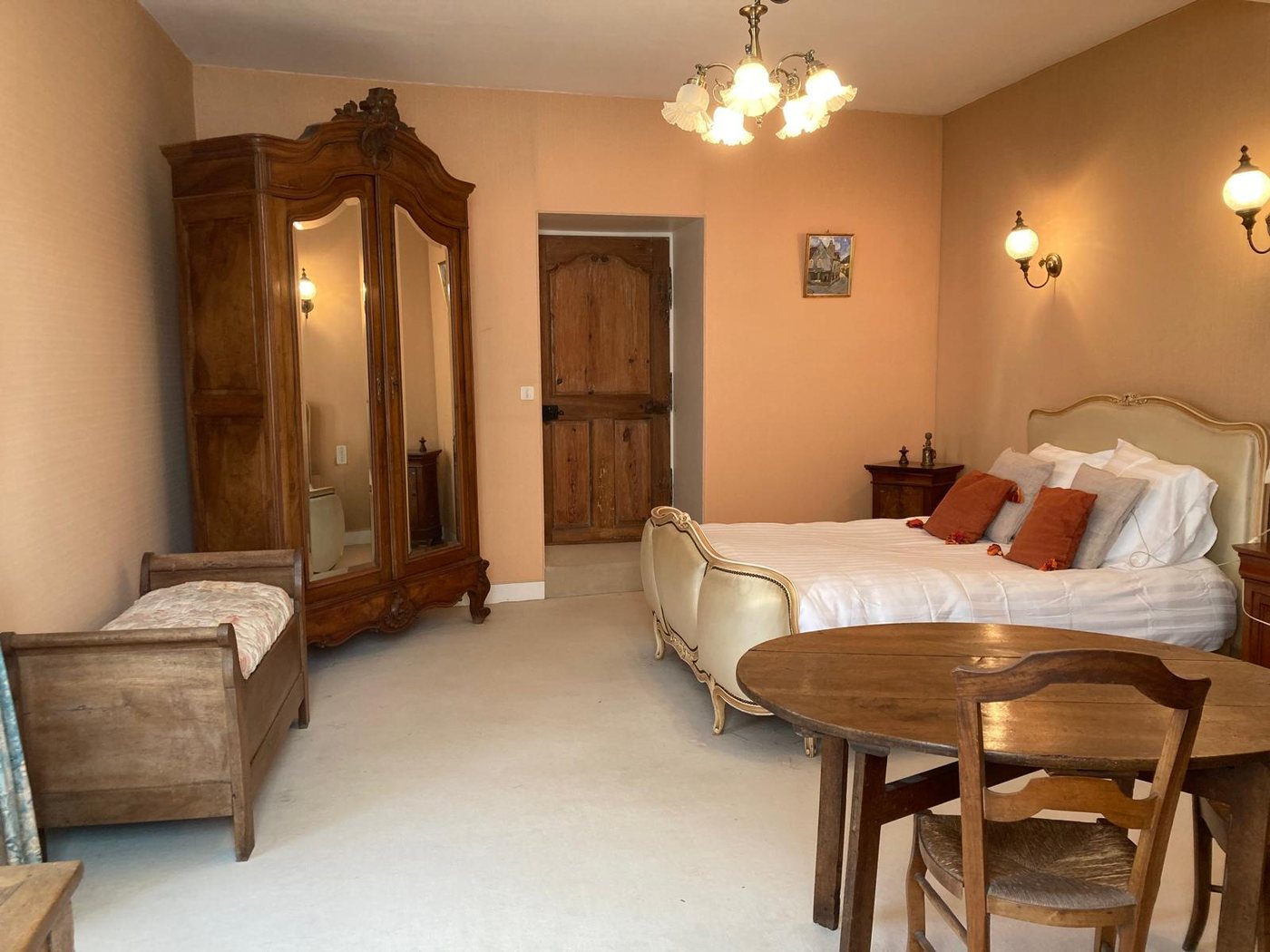 Chambre Hortense : lit ancien, grande armoire à glace et table ronde